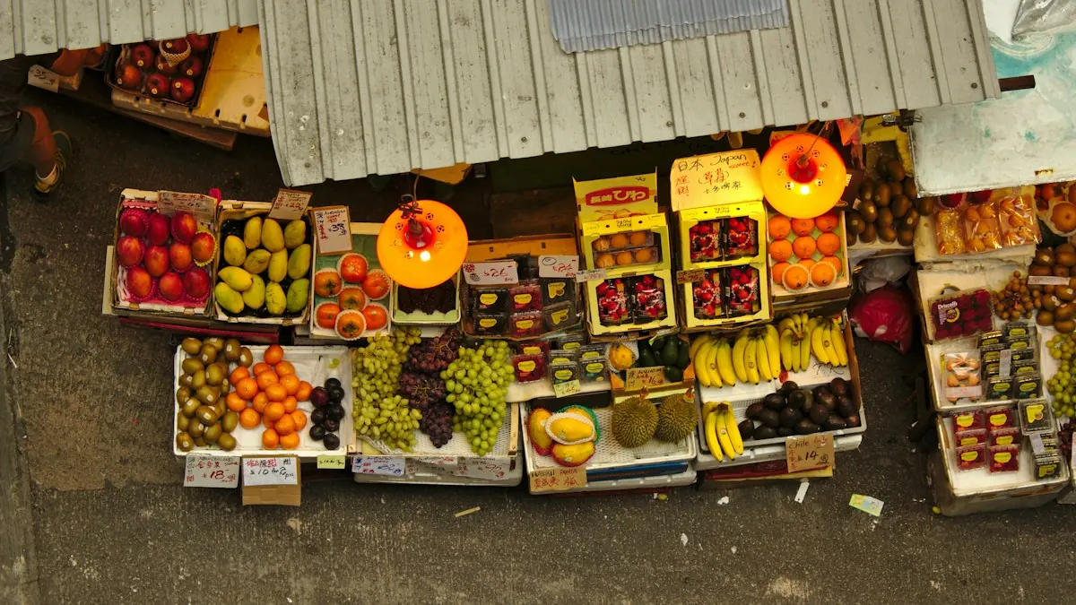 Looking down on a fruit stall with crates of grapes, oranges, bananas and dragon fruit